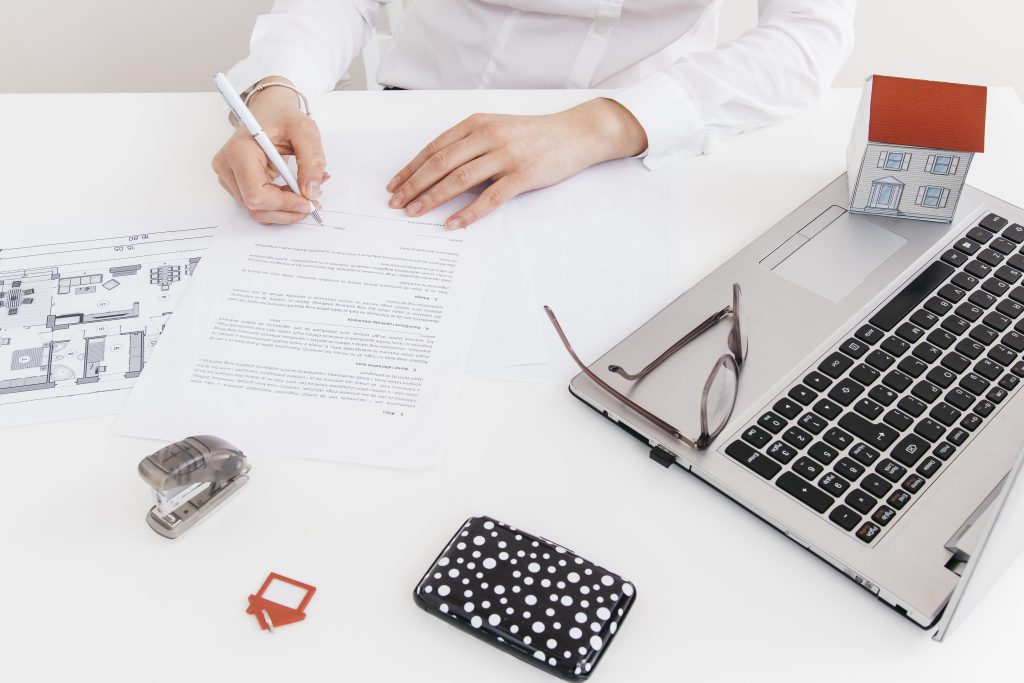overhead-view-human-hand-putting-signature-official-paper-office